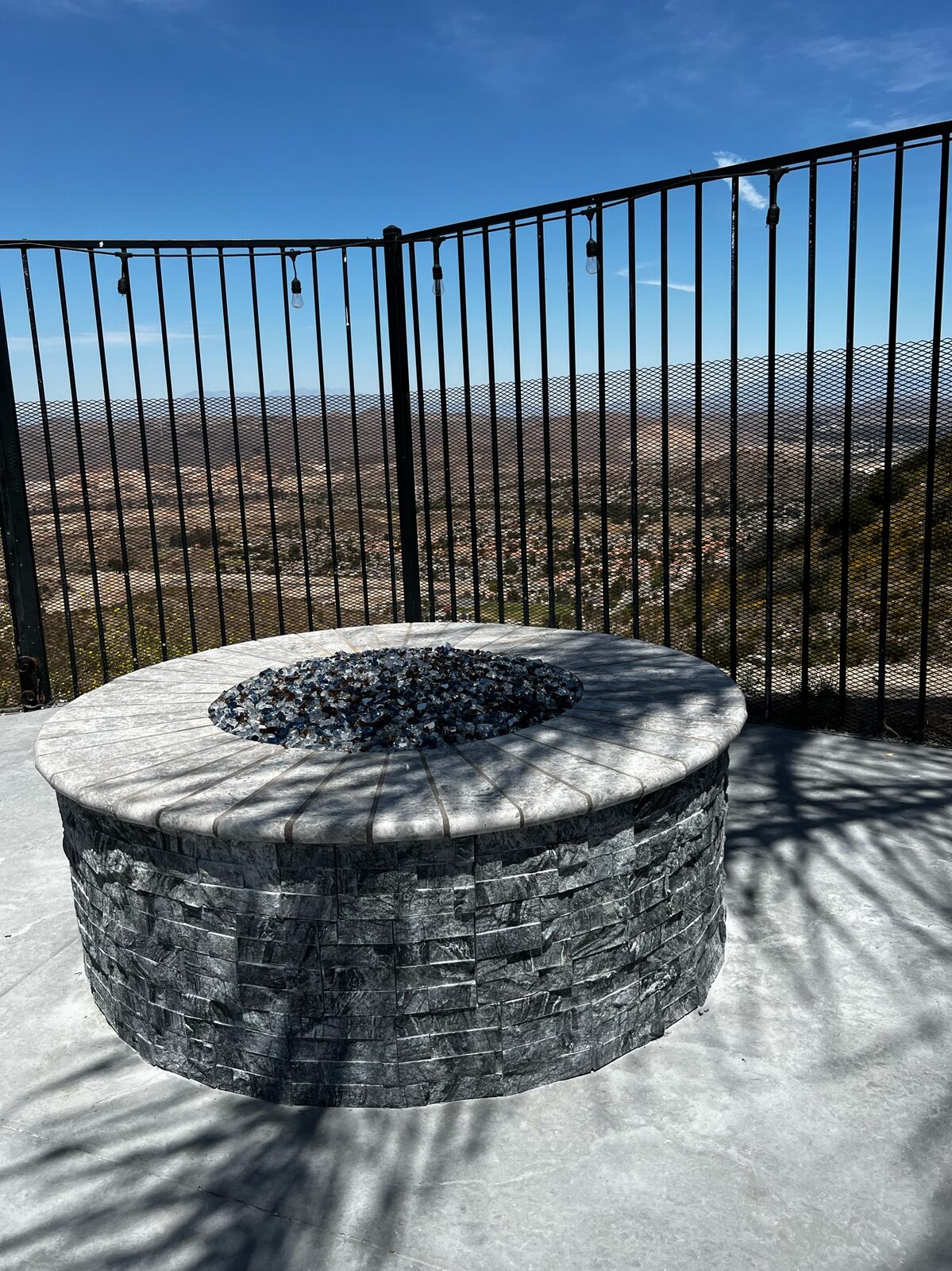 Round stacked stone fire pit overlooking valley view