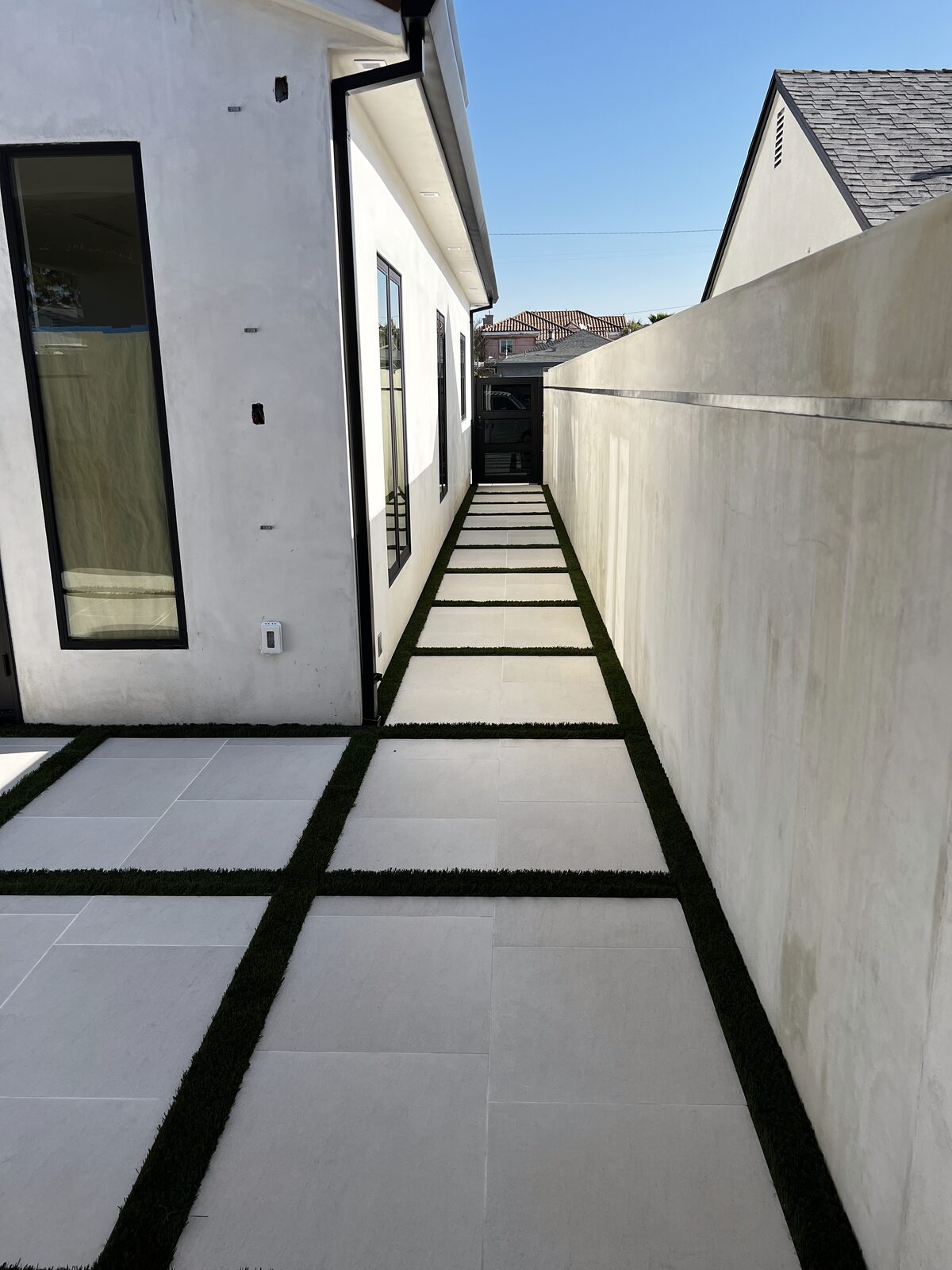 Large format pavers with turf strips in side yard